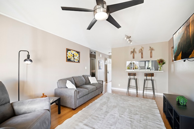 living room featuring ceiling fan and light wood-type flooring