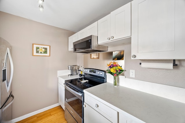 kitchen featuring white cabinetry, appliances with stainless steel finishes, and light wood-type flooring