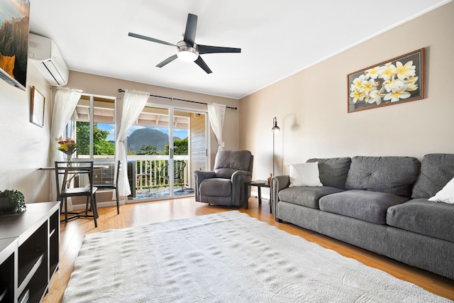 living room with light hardwood / wood-style flooring, a wall unit AC, and ceiling fan