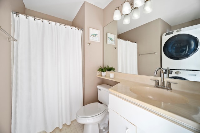 bathroom with toilet, vanity, and stacked washing maching and dryer