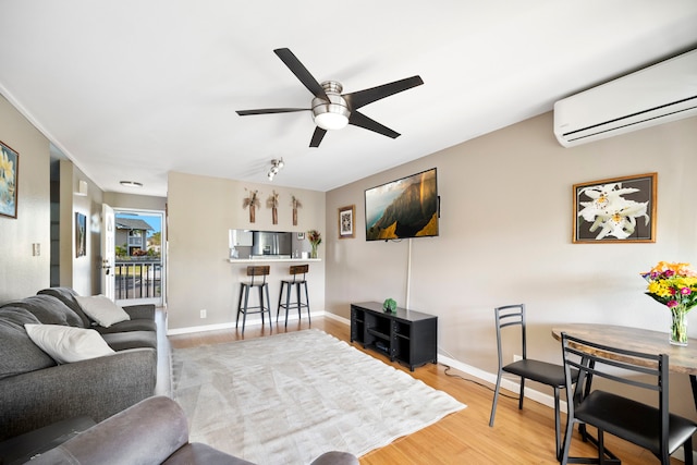 living room featuring ceiling fan, hardwood / wood-style flooring, and a wall mounted AC