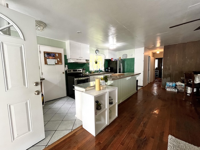 kitchen featuring white cabinetry, hardwood / wood-style flooring, stainless steel appliances, and a kitchen island