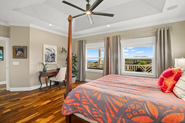 bedroom with dark wood-type flooring, ceiling fan, ornamental molding, and a tray ceiling