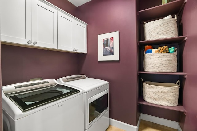 clothes washing area featuring cabinets and separate washer and dryer