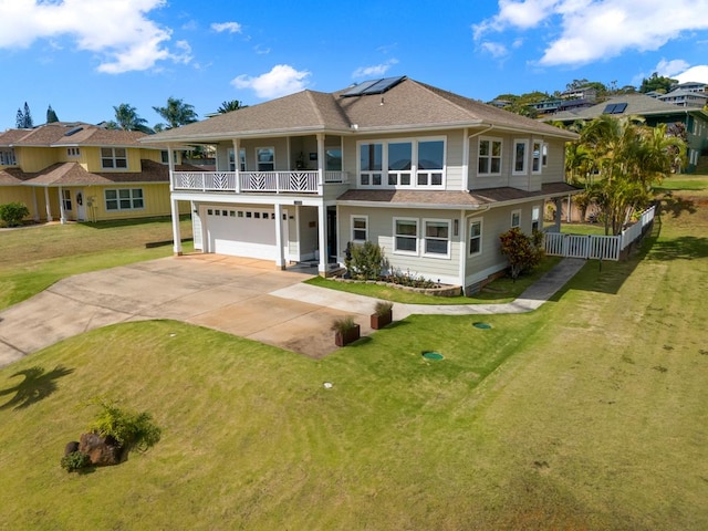 view of front of property with a balcony, a garage, a front lawn, and solar panels