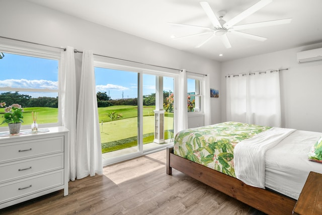 bedroom featuring ceiling fan, access to exterior, light hardwood / wood-style flooring, and an AC wall unit