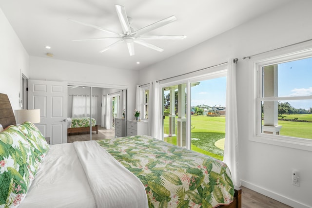 bedroom featuring dark hardwood / wood-style flooring, access to outside, a closet, and ceiling fan