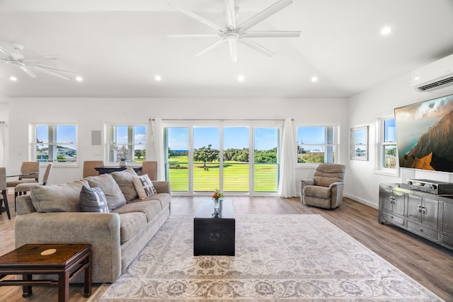 living room with ceiling fan, a wall mounted air conditioner, vaulted ceiling, and light wood-type flooring