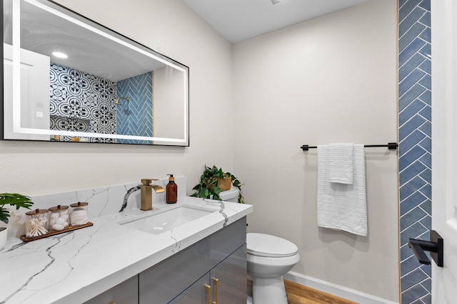 bathroom with vanity, hardwood / wood-style flooring, and toilet