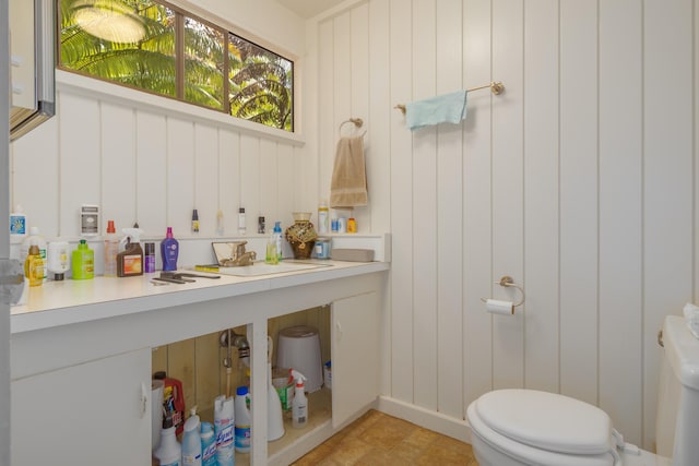 bathroom featuring sink and wood walls