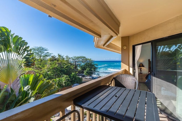 balcony featuring a beach view and a water view