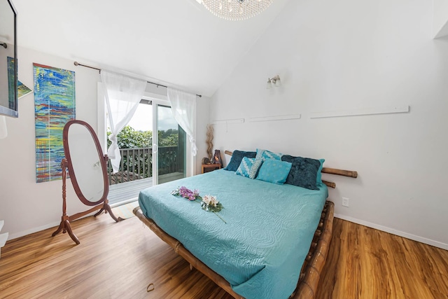 bedroom with hardwood / wood-style floors, vaulted ceiling, and access to outside