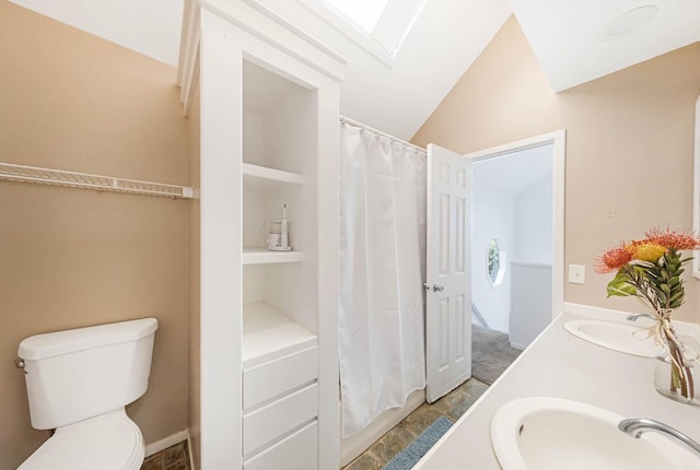 bathroom featuring lofted ceiling, vanity, toilet, and built in features