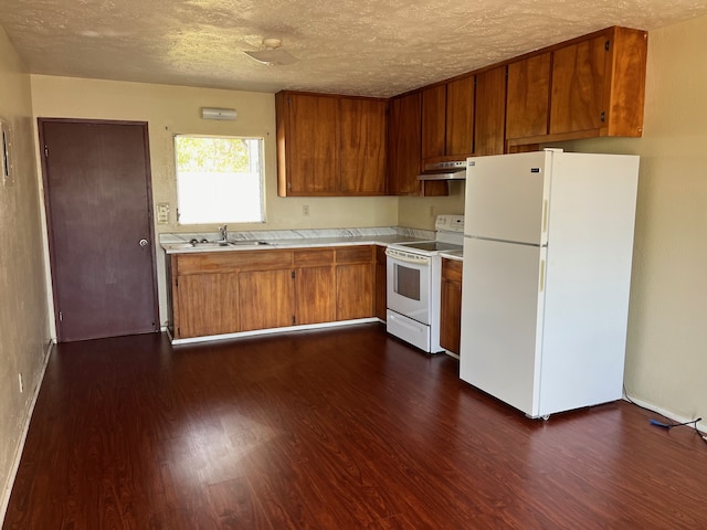 kitchen with dark hardwood / wood-style flooring, sink, white appliances, and a textured ceiling