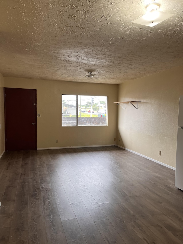 empty room featuring dark hardwood / wood-style floors and a textured ceiling