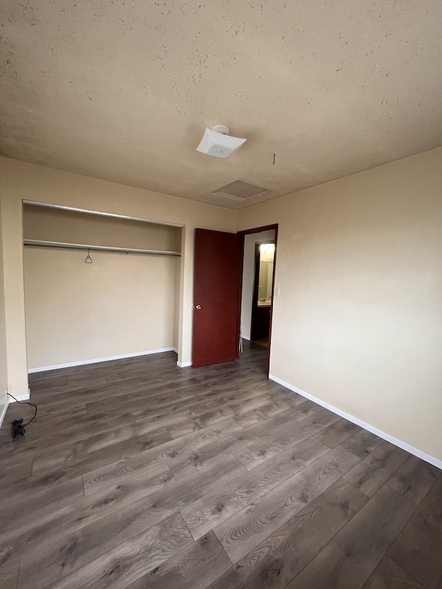 unfurnished bedroom with hardwood / wood-style flooring, a closet, and a textured ceiling