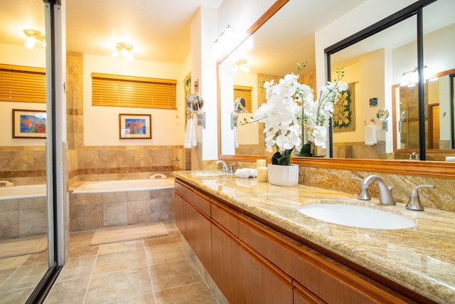 bathroom featuring vanity, tile patterned flooring, and tiled tub