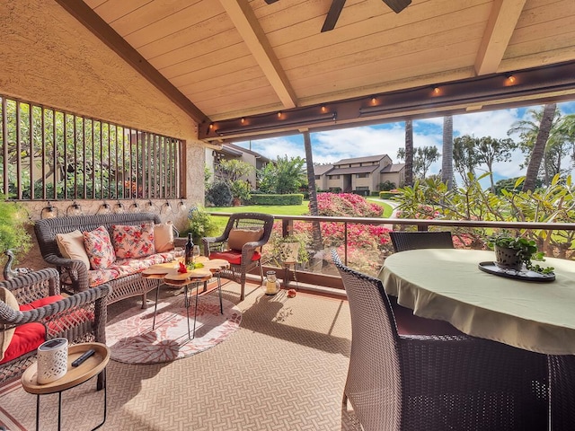 sunroom / solarium featuring vaulted ceiling with beams and ceiling fan