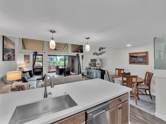 kitchen with vaulted ceiling, decorative light fixtures, dishwasher, sink, and dark hardwood / wood-style flooring