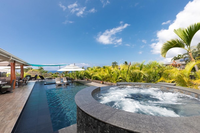 pool featuring a patio area and an in ground hot tub