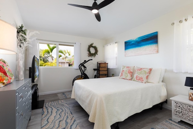 bedroom featuring ceiling fan, dark wood finished floors, and baseboards