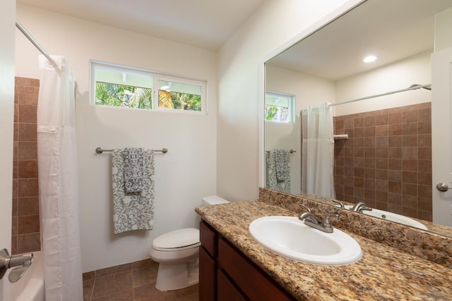 bathroom with toilet, tile patterned floors, vanity, and a healthy amount of sunlight