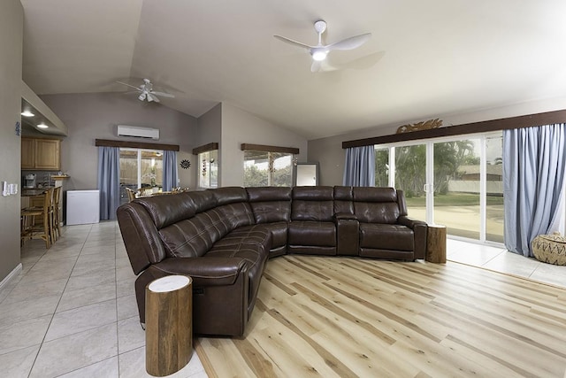 living room featuring vaulted ceiling, ceiling fan, light wood-type flooring, and an AC wall unit