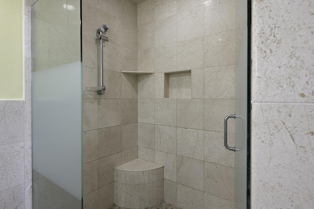 bathroom with a shower with door