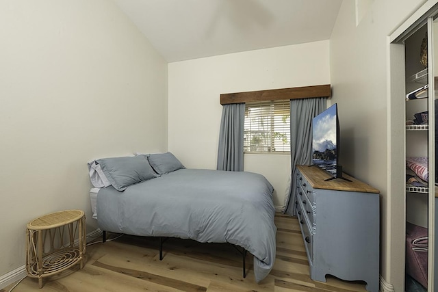 bedroom featuring lofted ceiling and light hardwood / wood-style flooring