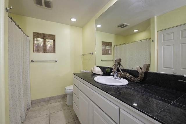 bathroom with vanity, toilet, and tile patterned flooring