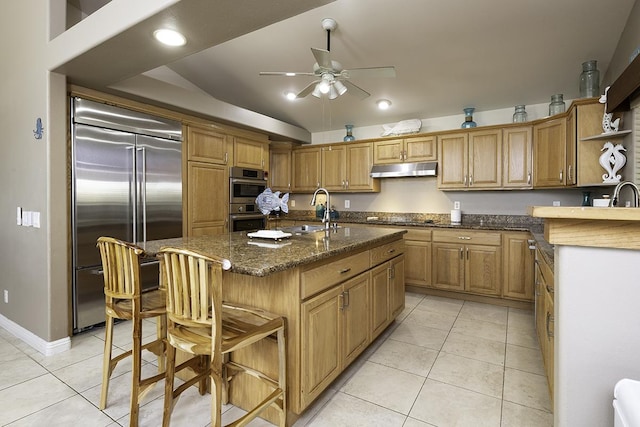 kitchen with sink, light tile patterned floors, a center island with sink, and appliances with stainless steel finishes