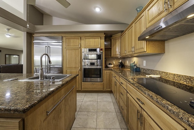 kitchen with lofted ceiling, sink, dark stone counters, a center island, and stainless steel appliances