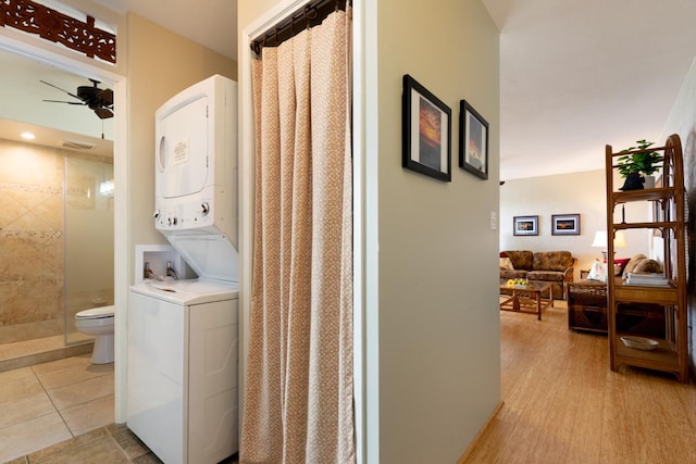 washroom with stacked washer / drying machine, light hardwood / wood-style flooring, and ceiling fan