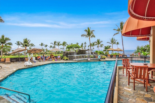 pool featuring a water view and a patio