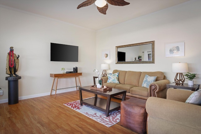 living room featuring crown molding, ceiling fan, baseboards, and wood finished floors