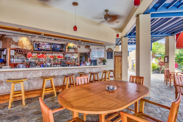 dining space featuring a bar and stone tile floors