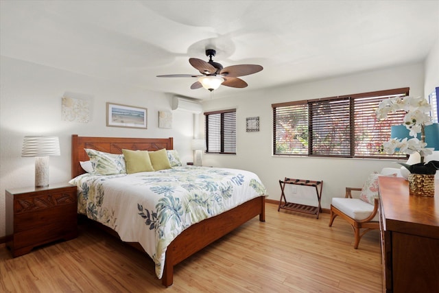 bedroom with ceiling fan, light wood-style flooring, and baseboards