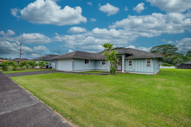 ranch-style home with a garage and a front lawn