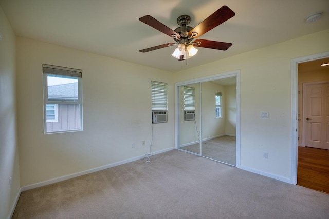 unfurnished bedroom featuring cooling unit, a closet, ceiling fan, and light carpet