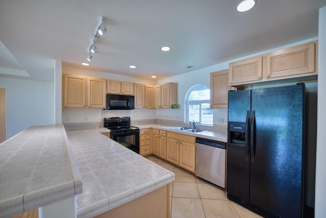 kitchen featuring light tile patterned flooring, tile countertops, light brown cabinets, kitchen peninsula, and black appliances