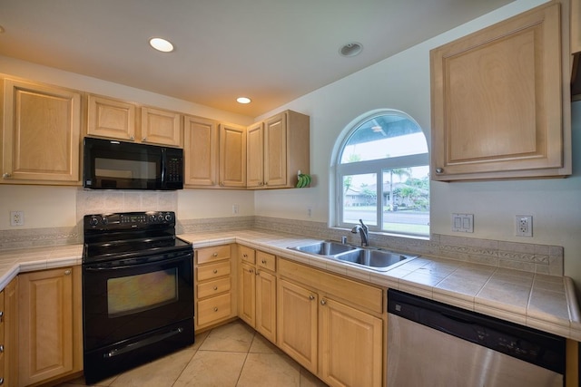 kitchen with light brown cabinetry, sink, tile counters, and black appliances