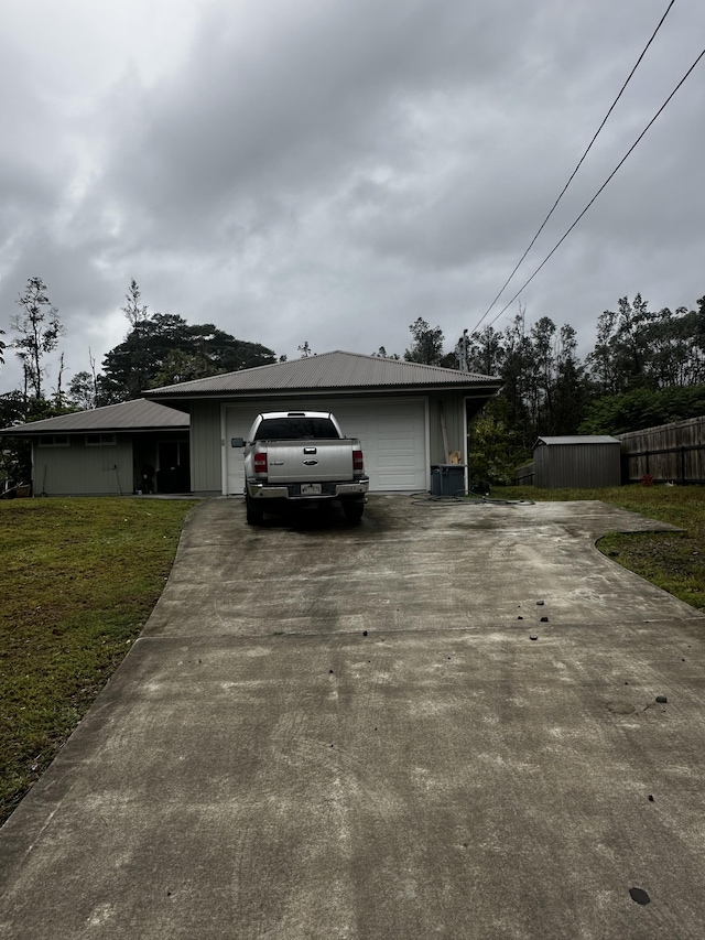 view of front of home featuring a garage, an outbuilding, and a front lawn