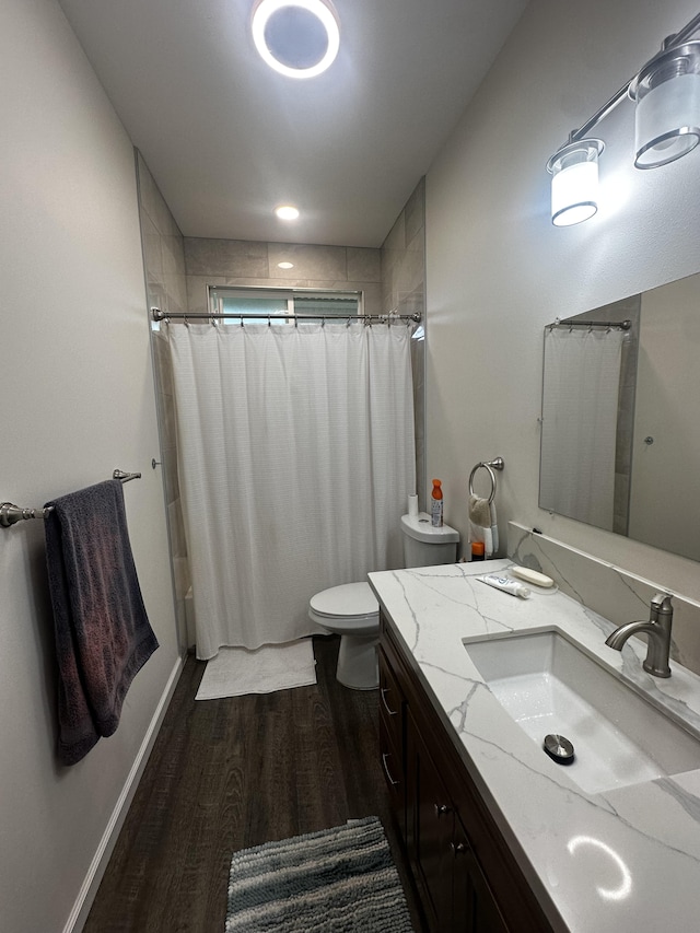 full bathroom featuring vanity, hardwood / wood-style floors, shower / tub combo with curtain, and toilet