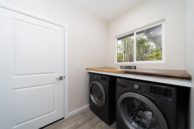 laundry area with light wood-type flooring and washing machine and dryer