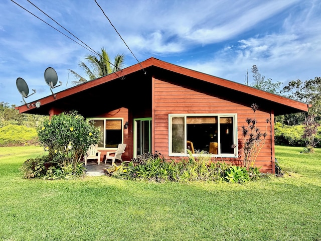 back of house with a lawn and a patio