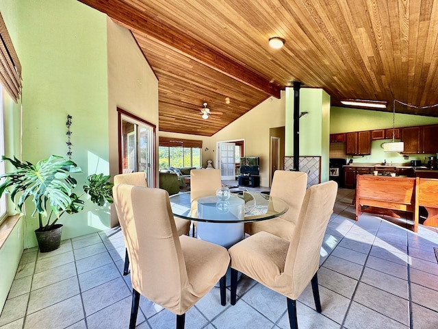 dining room featuring a wood stove, wood ceiling, lofted ceiling with beams, and light tile patterned flooring