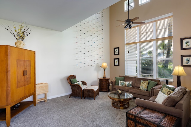 living room featuring carpet floors, plenty of natural light, and a towering ceiling