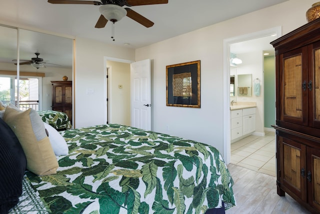 bedroom featuring ceiling fan, sink, ensuite bath, and light wood-type flooring