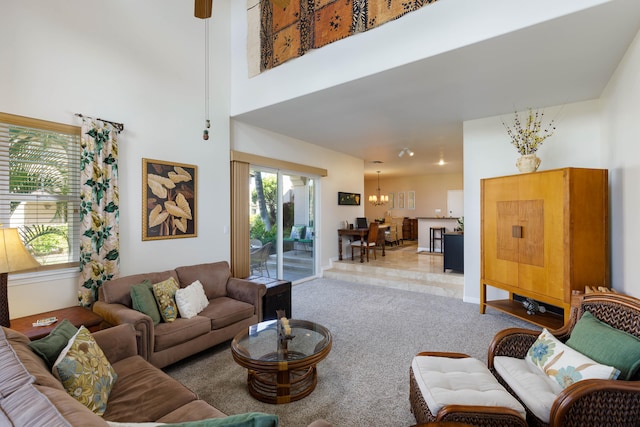 carpeted living room featuring a healthy amount of sunlight and a towering ceiling