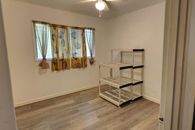 bedroom with light wood-style floors, multiple windows, baseboards, and a ceiling fan